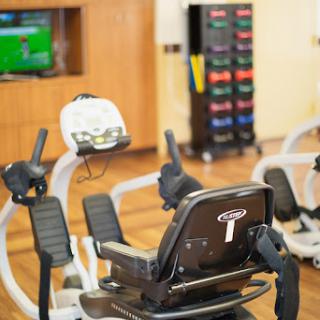 A well-equipped gym featuring a recumbent bike and a colorful storage area for fitness gear.
