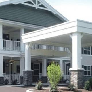 A modern residential building with a covered entrance and columns.