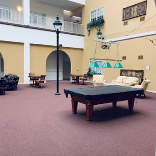 A spacious indoor lounge featuring a pool table and comfortable seating, designed for leisure and relaxation.