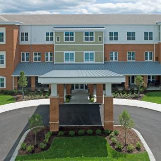 A front view of a modern residential building with landscaped grounds.