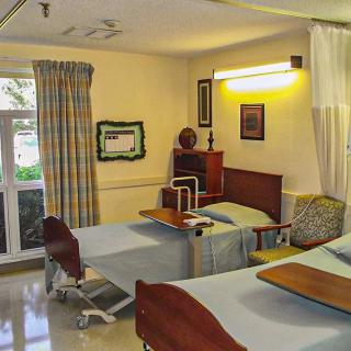 A hospital room with two patient beds and medical equipment.