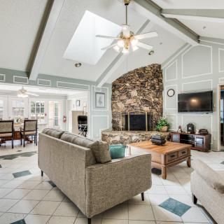 Spacious living room with skylights, a stone fireplace, and modern furnishings.