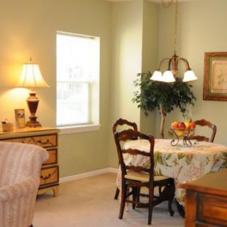 A cozy living and dining area with a table, chairs, and soft lighting.