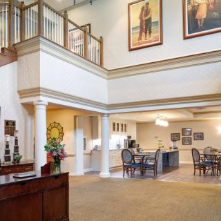 A spacious lobby area with a reception desk, seating arrangements, and artwork on the walls.