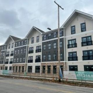 A modern apartment building under construction on a cloudy day.