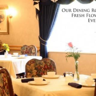 An elegantly set dining room with fresh flowers on each table.