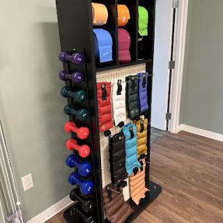 A well-organized fitness rack displaying various dumbbells and resistance bands, perfect for a home gym setup.