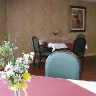 A small dining area with tables and chairs adorned with flowers.