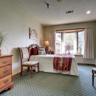 A cozy bedroom with elegant furnishings and a large window letting in natural light.