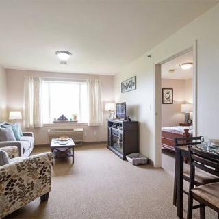 A cozy apartment living room featuring a comfortable seating area and a dining table.