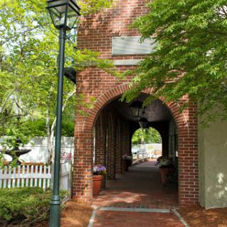 A charming brick archway leading to a scenic pathway, framed by lush greenery.