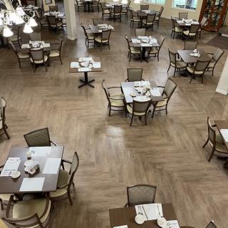 An empty restaurant dining area with neatly arranged tables and chairs.