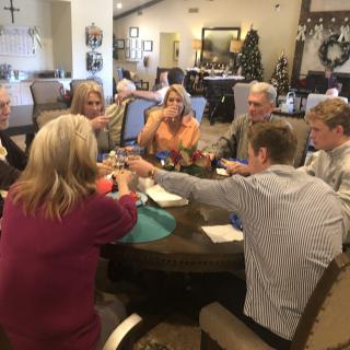 A group of people sitting around a dining table, enjoying a social gathering.