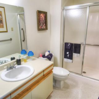 A well-organized bathroom with a sink, mirror, and shower.