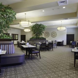 A spacious and elegantly decorated restaurant interior with arranged tables and chairs.