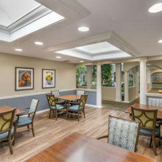 A well-lit dining area featuring tables, chairs, and decorative artwork on the walls.