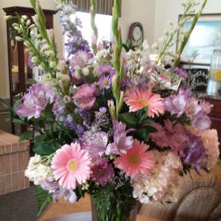 A beautiful floral arrangement featuring a blend of pink and purple flowers, perfect for brightening up any living space.