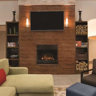 A stylish living room featuring a modern fireplace, built-in shelves, and comfortable seating.