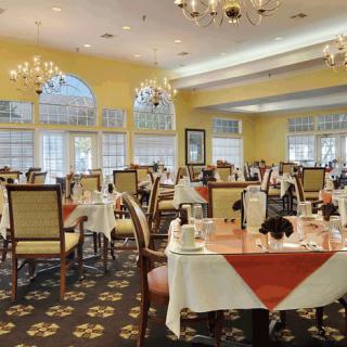 Elegant dining area with arranged tables and chandeliers.