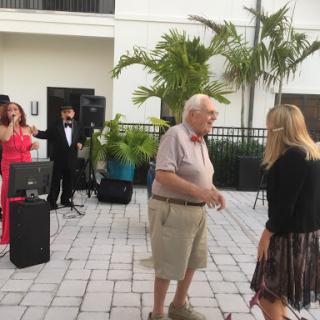 A lively outdoor party where guests are enjoying music and dancing.
