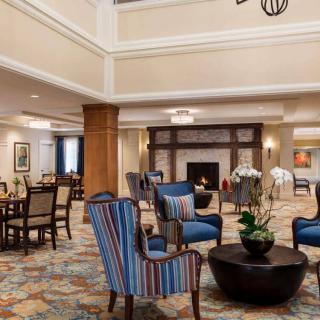 A spacious hotel lobby with comfortable seating and a fireplace.