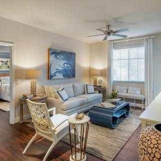 A cozy and stylish living room featuring a comfortable sofa, chic artwork, and abundant natural light.