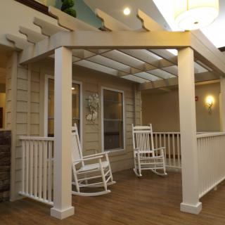 A cozy patio with a pergola and rocking chairs offering a comfortable outdoor seating area.