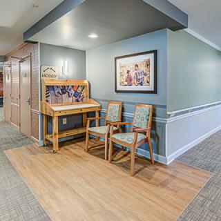 A cozy hallway corner with chairs and decorative artwork on the wall.