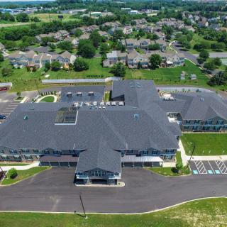 Aerial view of a large school building with a parking lot in a suburban neighborhood.