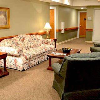 A cozy lobby seating area with a floral sofa and comfortable chairs.
