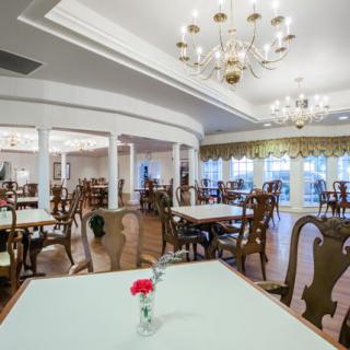 An elegant dining area featuring chandeliers and neatly arranged tables and chairs.