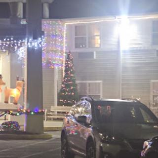 A festively decorated building with Christmas lights and a tree, illuminated at night.