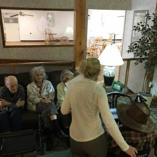 A group of people sitting and conversing in a cozy living room setting.