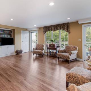 A bright and spacious living room with hardwood floors, comfortable seating, and large windows offering plenty of natural light.