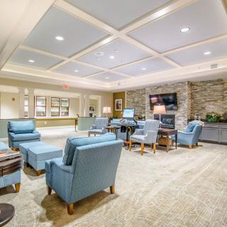 A well-furnished lobby with comfortable chairs and a television.