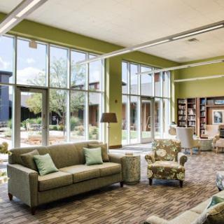 A bright and inviting lounge area featuring large windows, comfortable seating, and a serene atmosphere.