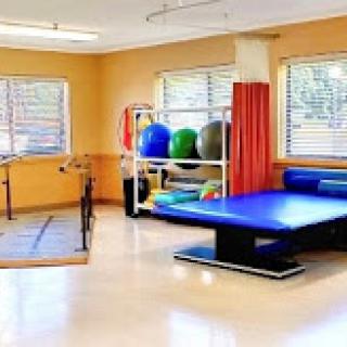 A bright and organized physical therapy room equipped with various exercise tools.