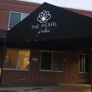 The entrance of The Pearl, featuring a prominent awning with its name.