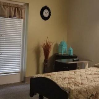 A cozy bedroom with a bed, decorative items, and a window with blinds.