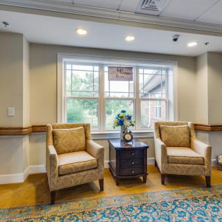 A cozy seating area with two chairs and a table by a large window.