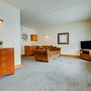 A cozy living room with a sofa, a television, and tasteful decor.