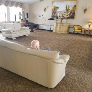 A spacious living room with sofas, a piano, and elegant decor.