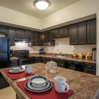 A modern kitchen with dark cabinets, appliances, and a set dining area on the countertop.