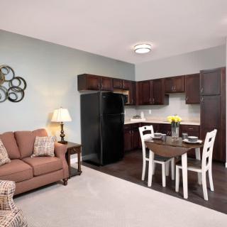 A cozy apartment interior featuring a kitchen, dining area, and living room with modern furniture.