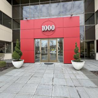 The main entrance of a modern building, featuring a prominent red facade and stylish landscaping.