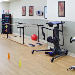 A physical therapy room equipped with exercise machines and rehabilitation tools.