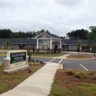 Entrance to a building with a driveway and sign.