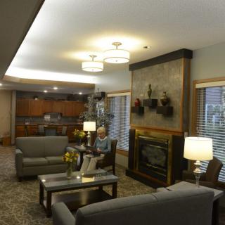 A cozy living room with comfortable seating, a fireplace, and warm lighting.