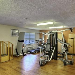 A small gym with various fitness equipment for strength training and exercise.