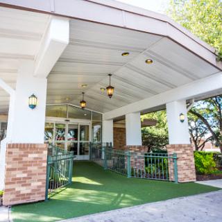 The welcoming entrance of a modern building, featuring an accessible pathway and stylish lighting.